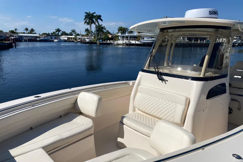 Slide: The Image of 2024 Grady-White Canyon 306 boat on calm water, featuring luxurious seating and modern design. - 12