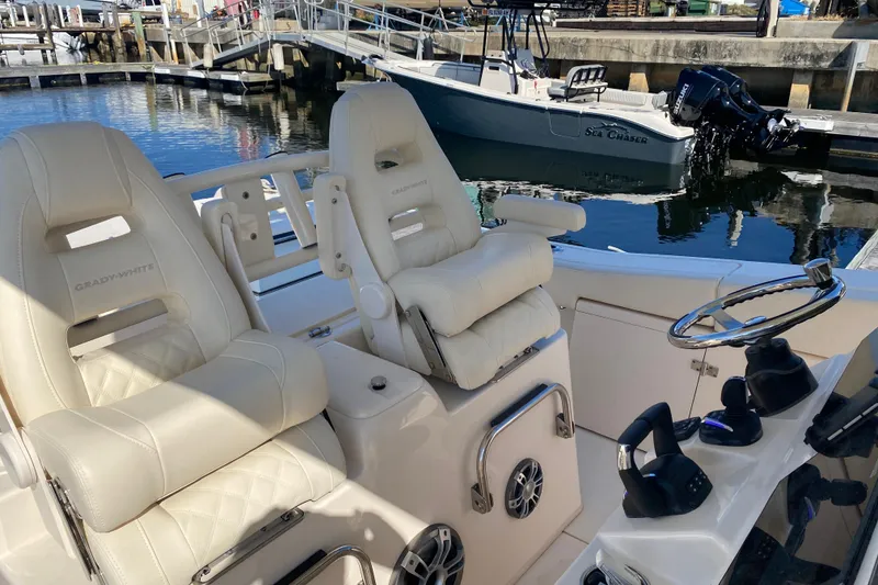 Slide: The Image of 2024 Grady-White Canyon 306 boat interior with luxurious seating and steering wheel. - 15