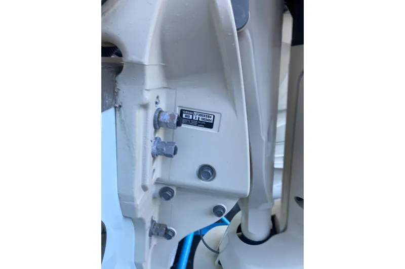 Slide: The Image of 2024 Grady-White Canyon 306 boat engine detail with visible bolts and label. - 17