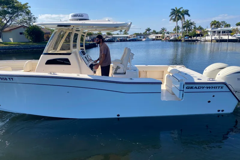 Slide: The Image of 2024 Grady-White Canyon 306 boat on calm water, featuring sleek design and modern equipment. - 2