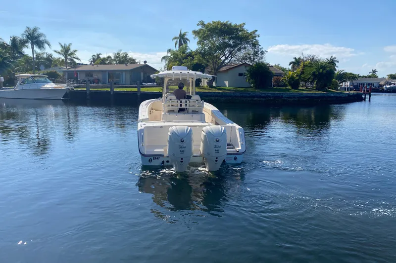 Slide: The Image of 2024 Grady-White Canyon 306 boat cruising on a sunny day in a residential canal. - 3