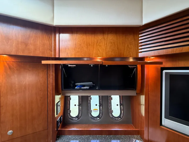 Slide: The Image of Yacht interior with wood paneling, two portholes, and an open cabinet. - 46