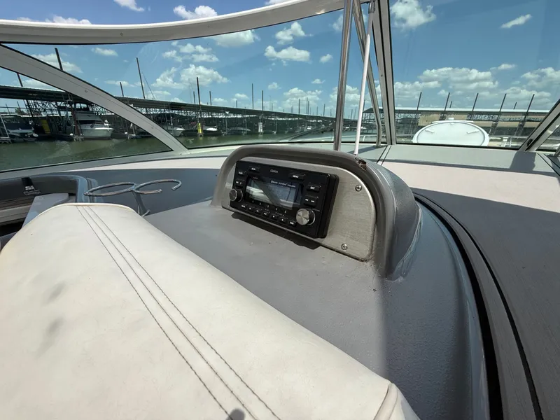 Slide: The Image of The cockpit of a 2007 Cruisers Yachts 420 Express with a radio and view of the marina. - 32