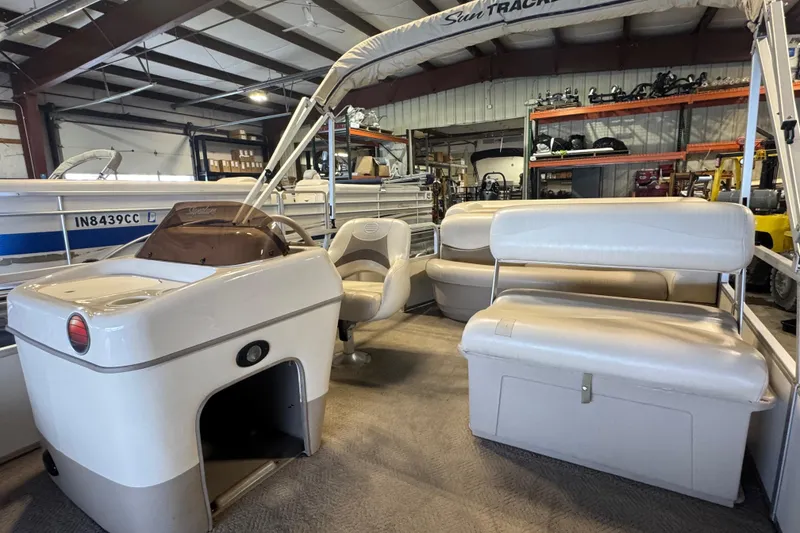 Slide: The Image of 2007 Sun Tracker Party Barge 18 Signature Series interior with seating and helm in warehouse. - 10