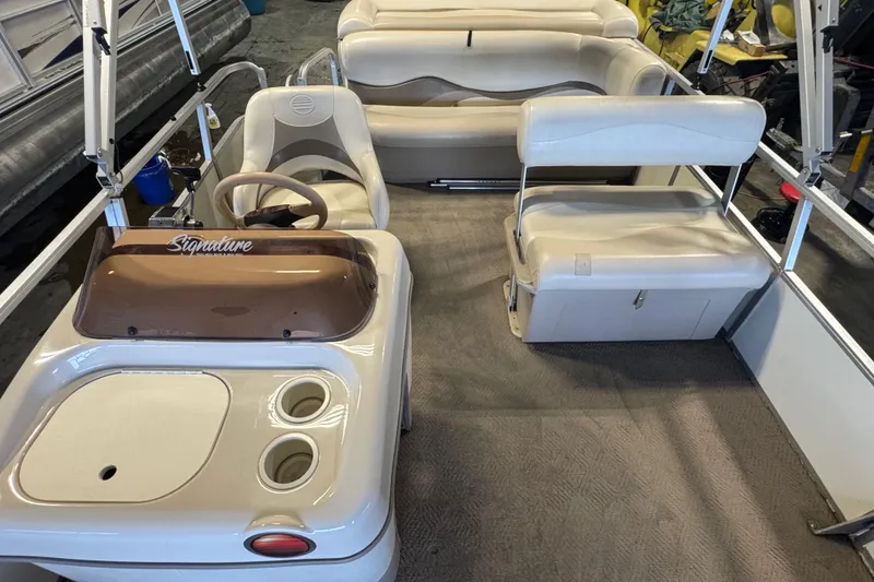 Slide: The Image of 2007 Sun Tracker Party Barge 18 Signature Series interior with beige seating and steering console. - 11