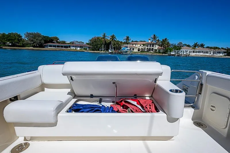 Slide: The Image of 2006 Pursuit 345 Drummond Runner LS boat with open storage compartment, scenic waterfront view. - 22