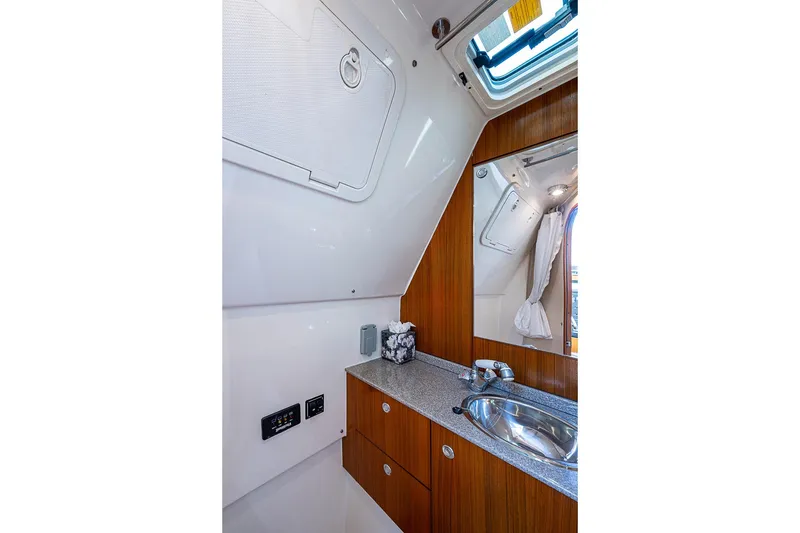 Slide: The Image of 2006 Pursuit 345 Drummond Runner LS boat interior with sink and wooden cabinetry. - 26