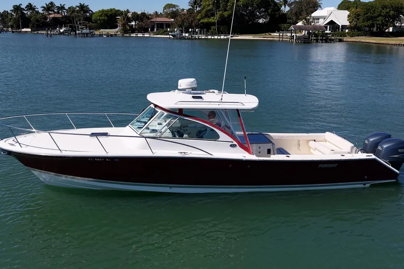 Slide: The Image of 2006 Pursuit 345 Drummond Runner LS boat on calm water, near shoreline homes. - 29