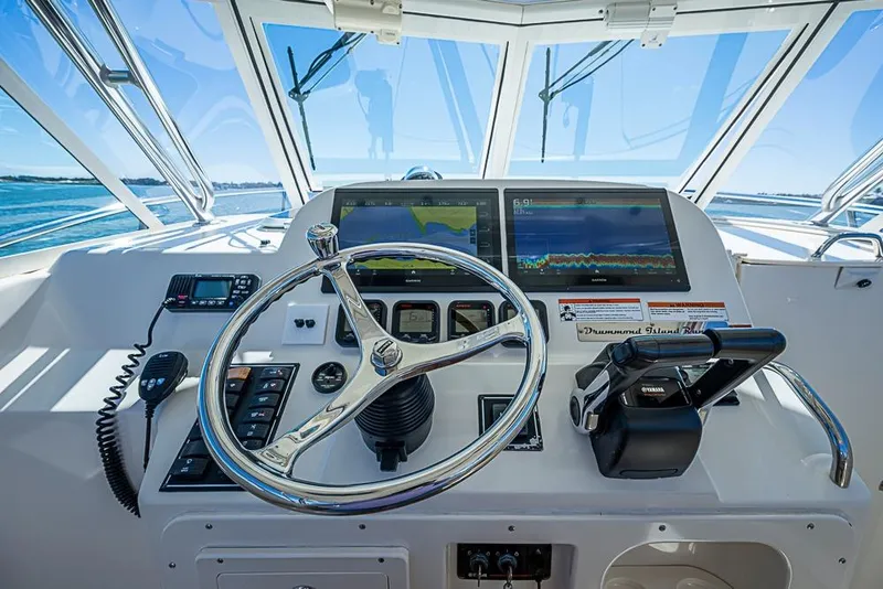 Slide: The Image of Helm of 2006 Pursuit 345 Drummond Runner LS with navigation screens and controls. - 9
