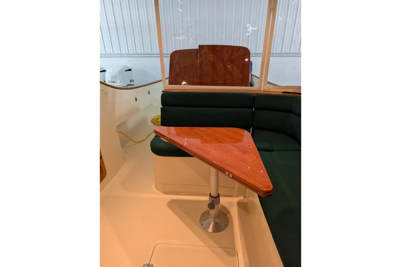 Slide: The Image of Interior of 2005 Hinckley Picnic Boat 36 EP with wooden table and green seating. - 26