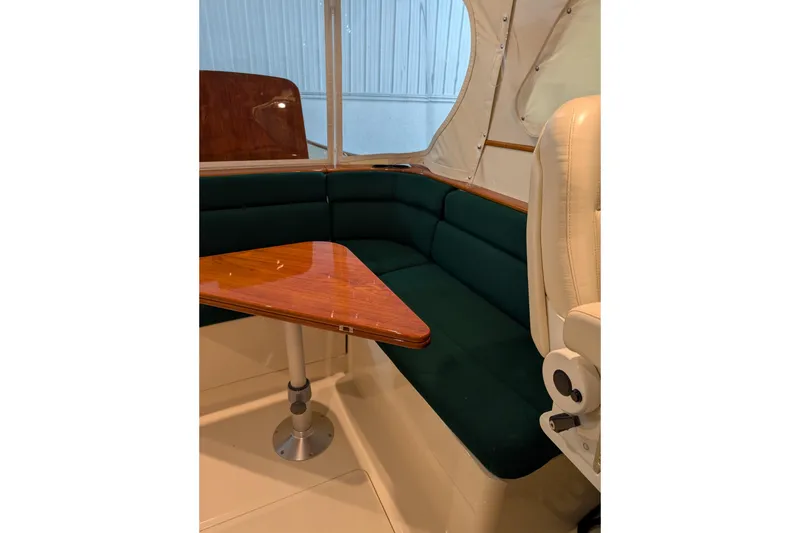 Slide: The Image of Interior of 2005 Hinckley Picnic Boat 36 EP with green seating and wooden table. - 28