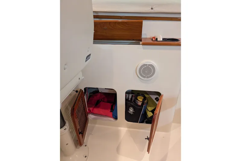 Slide: The Image of Storage compartments on a 2005 Hinckley Picnic Boat 36 EP, featuring wooden doors and organized items. - 30