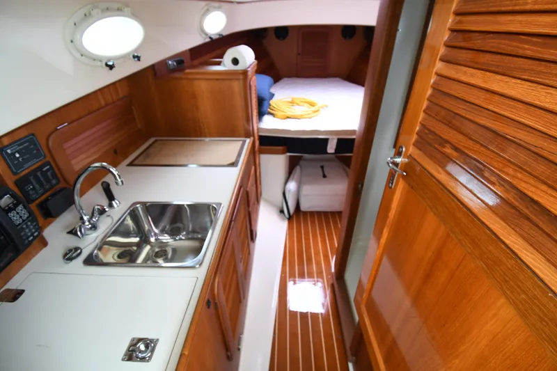 Slide: The Image of Interior of 2005 Hinckley Picnic Boat 36 EP with wooden cabinetry and compact kitchen area. - 25