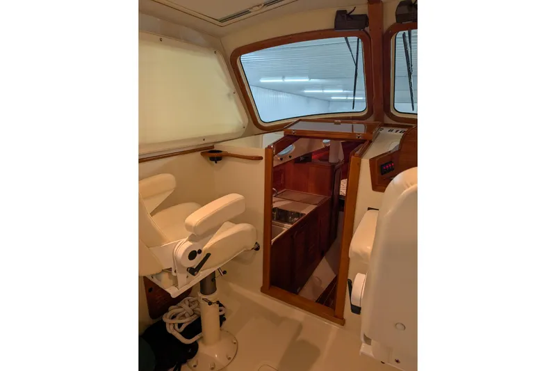 Slide: The Image of Interior of 2005 Hinckley Picnic Boat 36 EP, featuring helm seat and cabin entrance. - 38