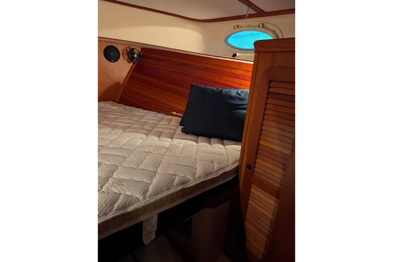 Slide: The Image of Cozy cabin interior of 2005 Hinckley Picnic Boat 36 EP with wooden accents and bedding. - 41