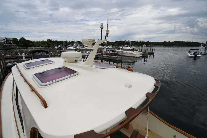 Slide: The Image of 2005 Hinckley Picnic Boat 36 EP docked at a marina under cloudy skies. - 5
