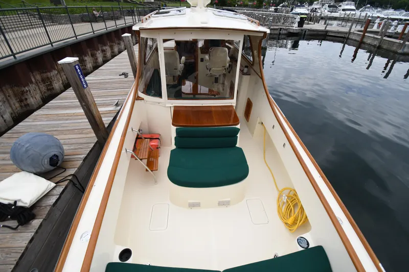 Slide: The Image of 2005 Hinckley Picnic Boat 36 EP docked, featuring green seating and wooden accents. - 12