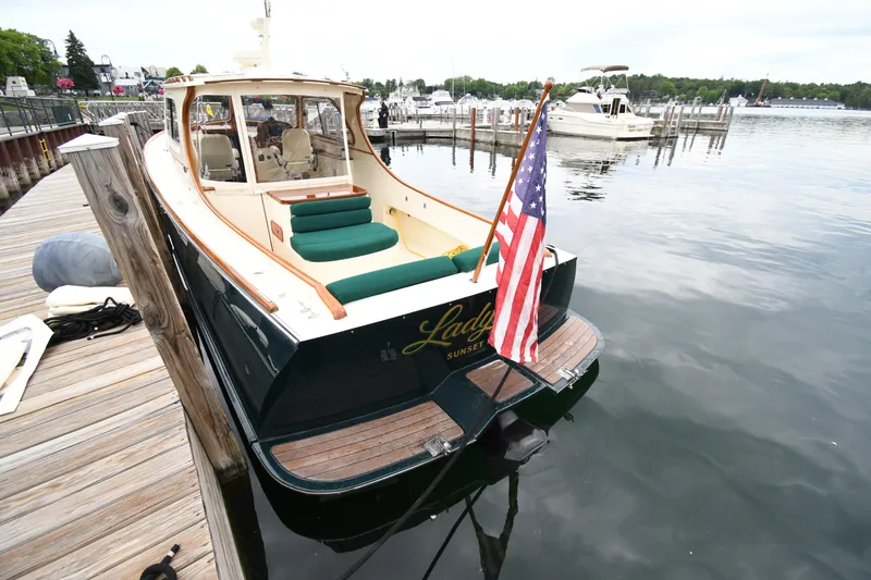 Slide: The Image of 2005 Hinckley Picnic Boat 36 EP docked, displaying an American flag, with a scenic marina backdrop. - 10