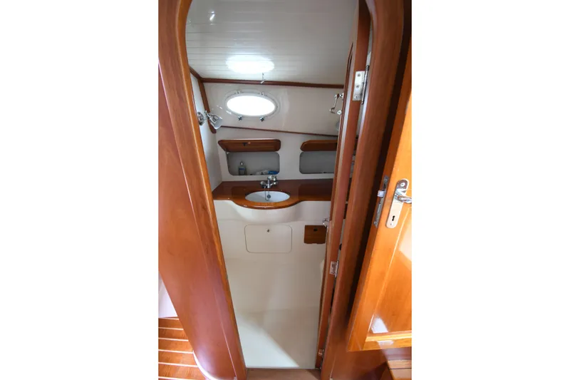Slide: The Image of 2005 Hinckley Picnic Boat 36 EP bathroom interior with wooden finish and sink. - 31