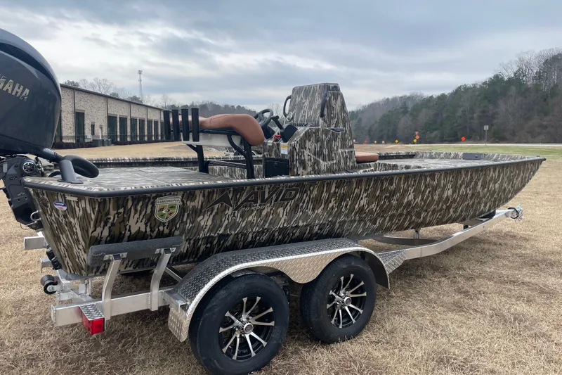 Slide: The Image of Avid 20 Rogue CC 2026 boat with camouflage design on a trailer outdoors. - 4