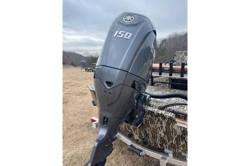 Slide: The Image of Outboard motor on 2026 Avid 20 Rogue CC boat, parked on grassy field. - 5