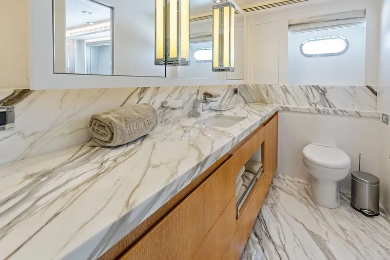 Slide: The Image of Luxurious yacht bathroom with marble countertops, wooden cabinetry, and modern fixtures on Horizon RP 110, 2014. - 47
