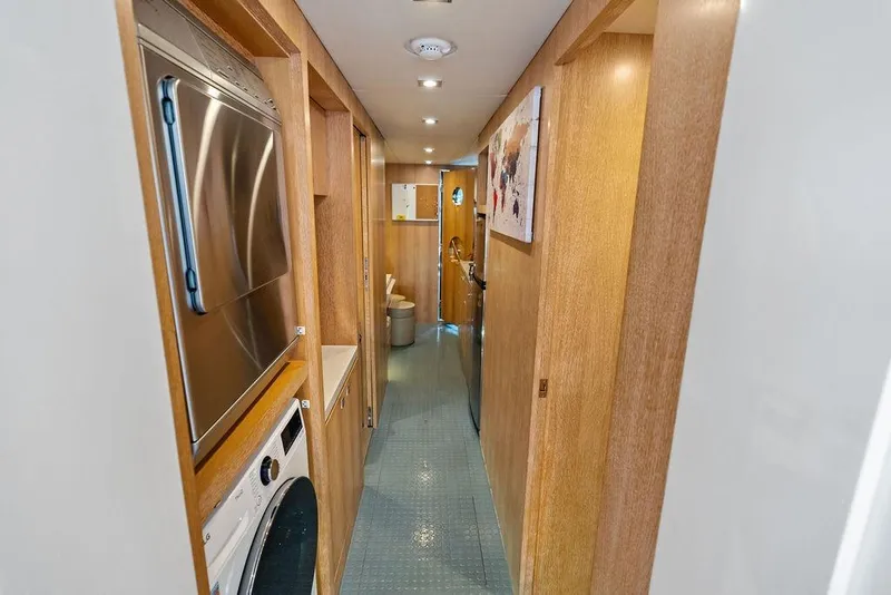Slide: The Image of Narrow hallway in 2014 Horizon RP 110 yacht with laundry appliances and wooden paneling. - 96