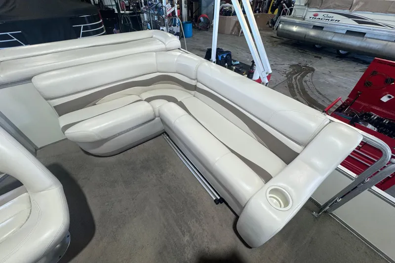 Slide: The Image of 2008 Sun Tracker Party Barge 200 Classic Series with white seating in a garage setting. - 12