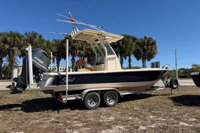 Slide: The Image of 2014 Scout 251 XS boat on trailer with Yamaha engine, parked outdoors. - 0