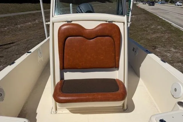 Slide: The Image of 2014 Scout 251 XS boat with brown cushioned seating, outdoor view. - 10