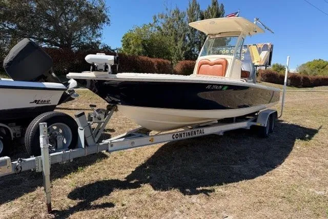 Slide: The Image of 2014 Scout 251 XS boat on trailer, parked on grass under clear sky. - 5