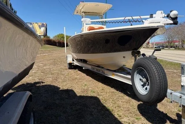 Slide: The Image of 2014 Scout 251 XS boat on trailer, parked on grass beside a road. - 6
