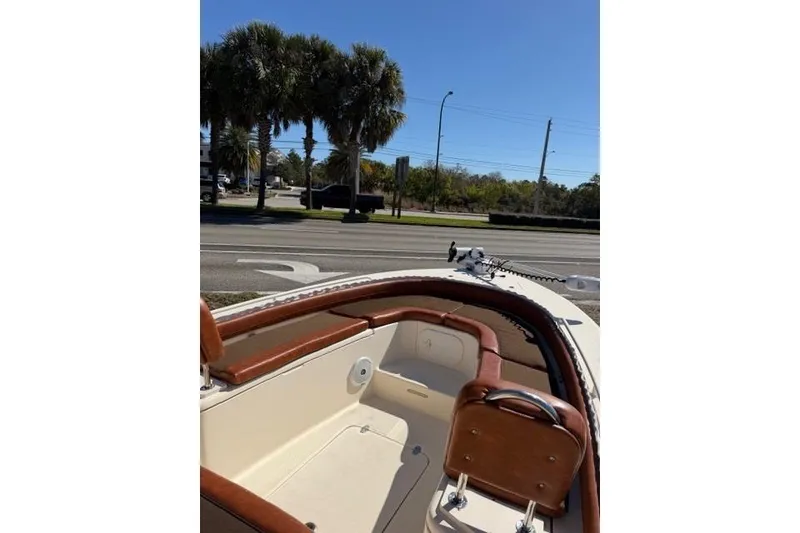 Slide: The Image of 2014 Scout 251 XS boat interior with brown leather accents, parked near palm trees. - 9