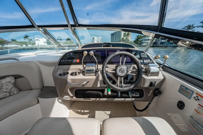 Slide: The Image of 2008 Chaparral Signature 350 boat cockpit with steering wheel and controls, under clear blue sky. - 10