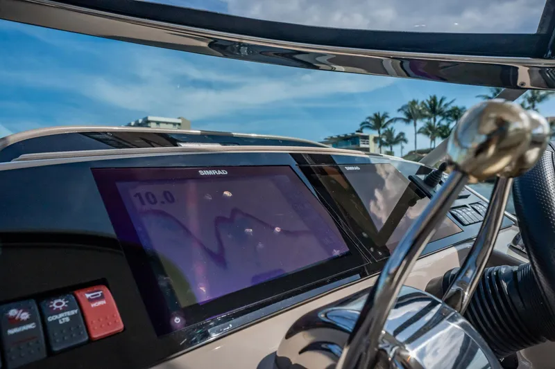 Slide: The Image of 2008 Chaparral Signature 350 dashboard with Simrad display and controls, under clear blue sky. - 11