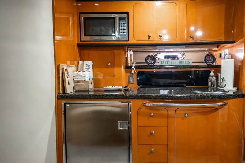 Slide: The Image of 2008 Chaparral Signature 350 yacht kitchen with microwave, cabinets, and stainless steel fridge. - 18
