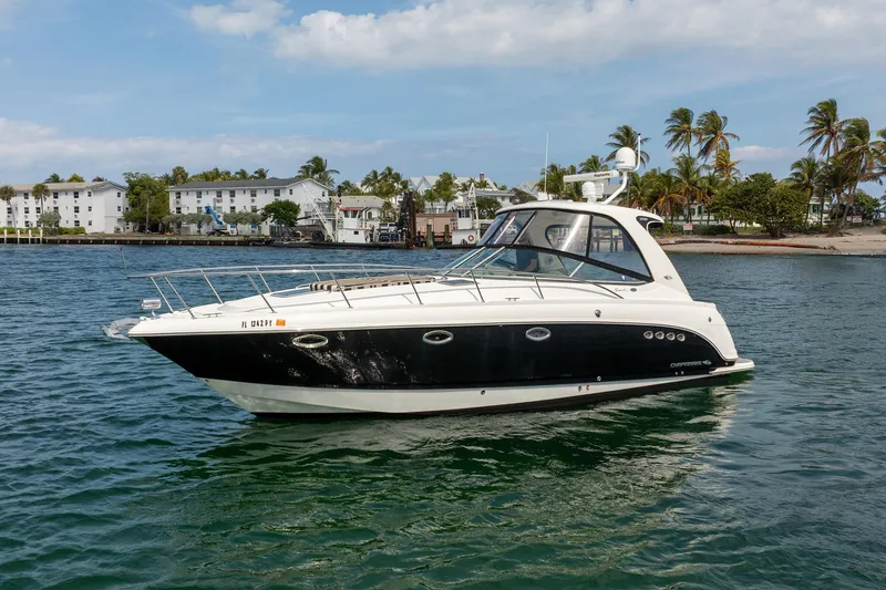 Slide: The Image of 2008 Chaparral Signature 350 boat on water, with palm trees and buildings in the background. - 2