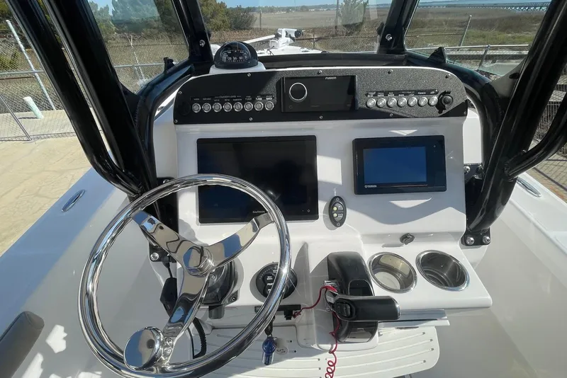 Slide: The Image of 2019 Everglades 243 Center Console boat dashboard with steering wheel and navigation screens. - 13