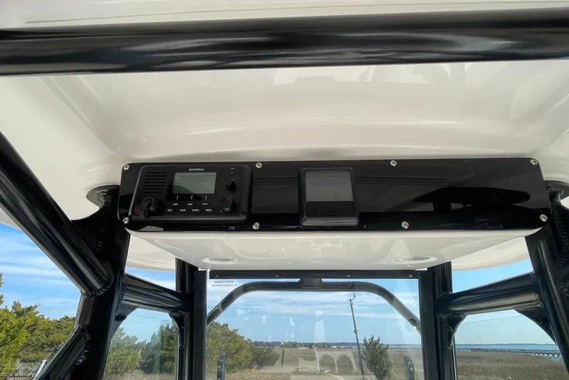 Slide: The Image of 2019 Everglades 243 Center Console boat with Garmin electronics, featuring a sleek black console. - 16