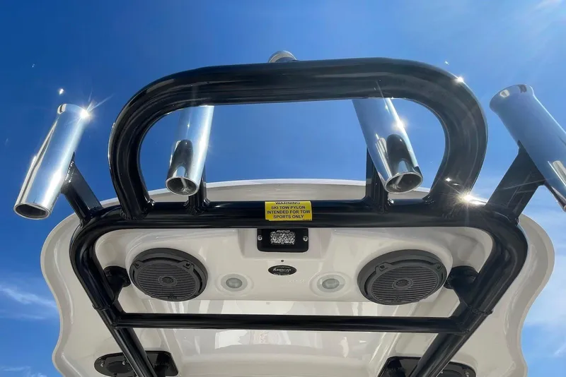 Slide: The Image of 2019 Everglades 243 Center Console boat with rod holders and speakers under a clear blue sky. - 17