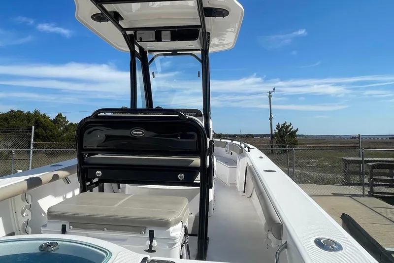 Slide: The Image of 2019 Everglades 243 Center Console boat with seating, docked under clear blue sky. - 9