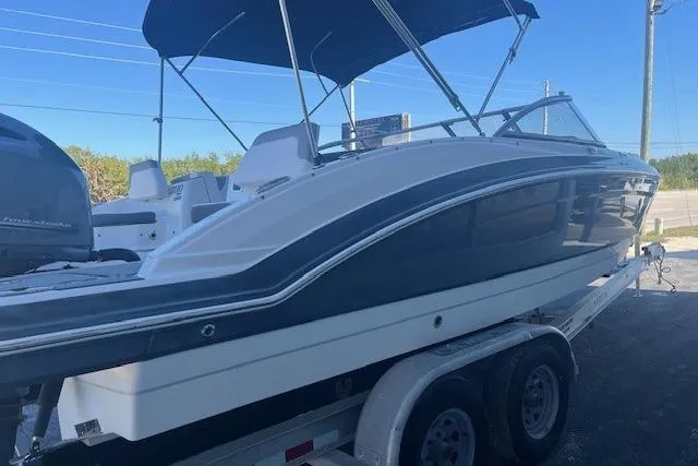 Slide: The Image of 2021 Chaparral 230 Suncoast boat on trailer with canopy, parked outdoors. - 3