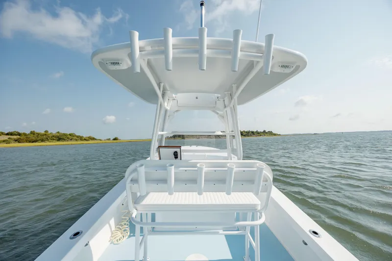 Slide: The Image of 2019 Gamefisherman 26 Cuddy Cabin boat on calm water, clear sky background. - 16