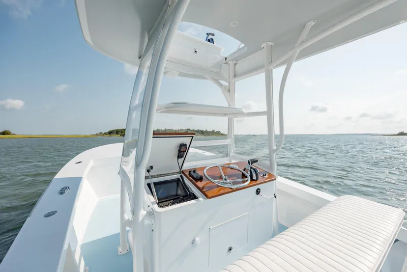 Slide: The Image of 2019 Gamefisherman 26 Cuddy Cabin boat interior with steering wheel, on open water. - 17