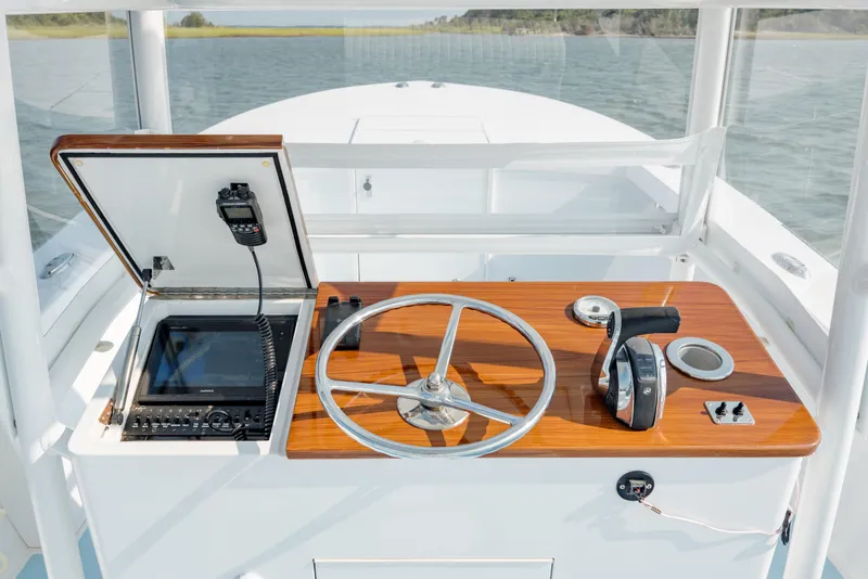 Slide: The Image of 2019 Gamefisherman 26 Cuddy Cabin helm with steering wheel and navigation equipment. - 18