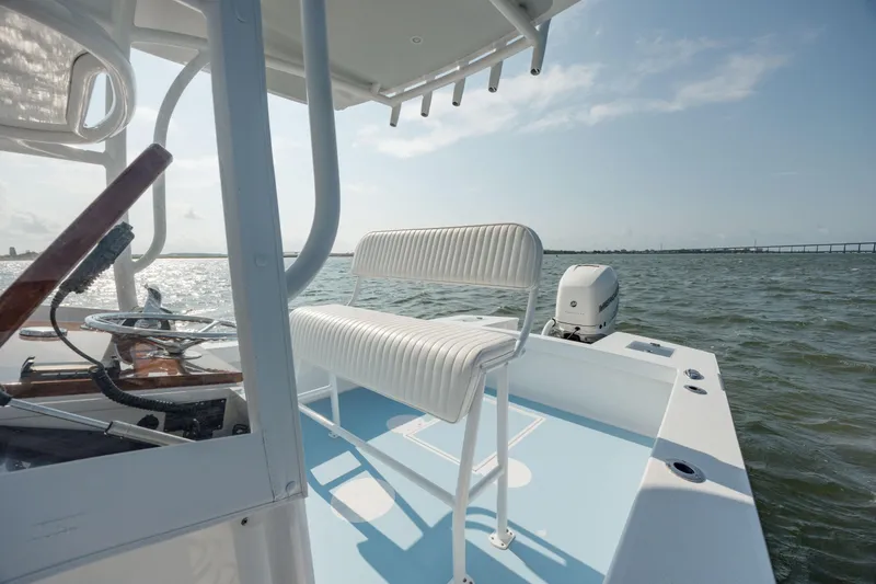 Slide: The Image of 2019 Gamefisherman 26 Cuddy Cabin boat on water, featuring helm and seating. - 20