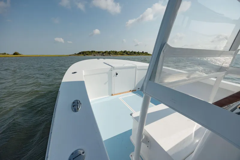 Slide: The Image of 2019 Gamefisherman 26 Cuddy Cabin boat on water, clear sky, distant island view. - 21