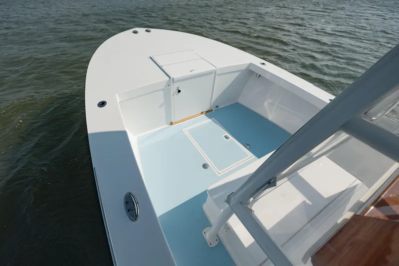 Slide: The Image of 2019 Gamefisherman 26 Cuddy Cabin boat on water, showcasing spacious deck and sleek design. - 26