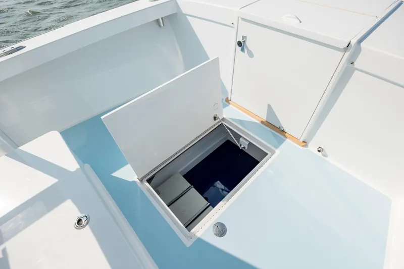 Slide: The Image of 2019 Gamefisherman 26 Cuddy Cabin boat with open storage compartment on deck. - 29