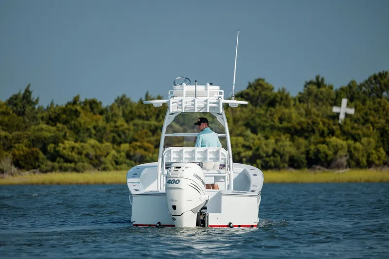 Slide: The Image of 2019 Gamefisherman 26 Cuddy Cabin boat cruising on a calm lake. - 3